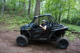 A man riding in the back of an atv.
