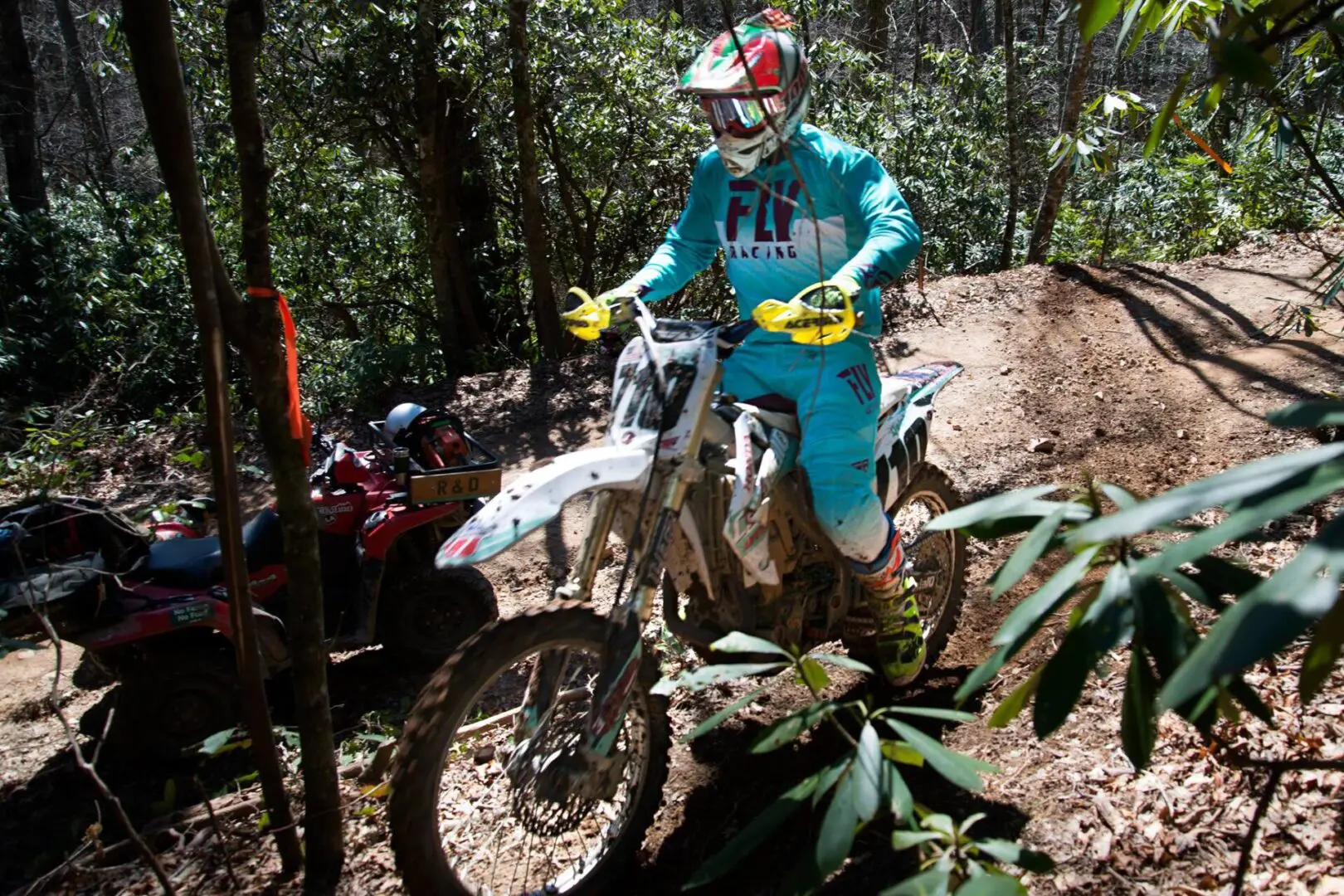 A person on a dirt bike riding in the woods.